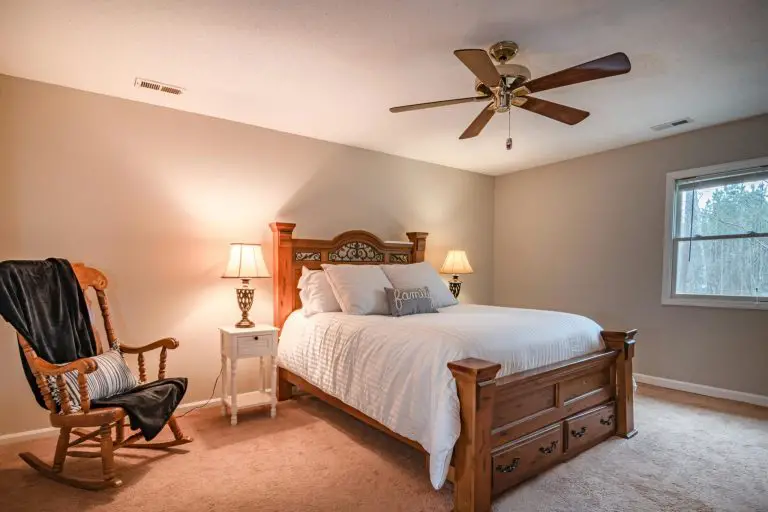Cozy bedroom with wooden bed and rocking chair.