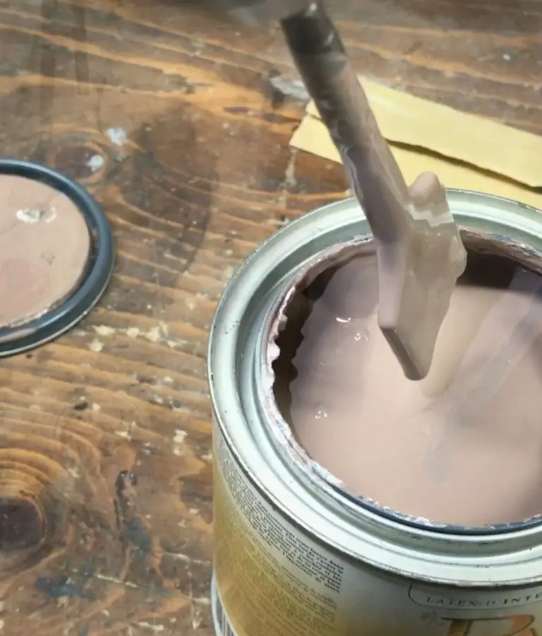 Mixing beige paint in open can.