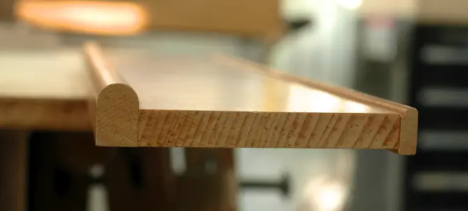 This cross section of three-piece trim frame includes decorative bullnose strips add to the outside edge of the frame (left) and the inside edge (right). Note how the right-hand strip extends down past the frame.