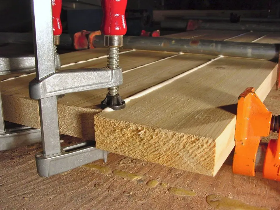 Almost every table design involving solid wood requires boards be glued together to make the top. Here a table top blank is in the clamps in my shop. Notice how small clamps are used on the ends to align boards and minimize board-to-board mismatch.
