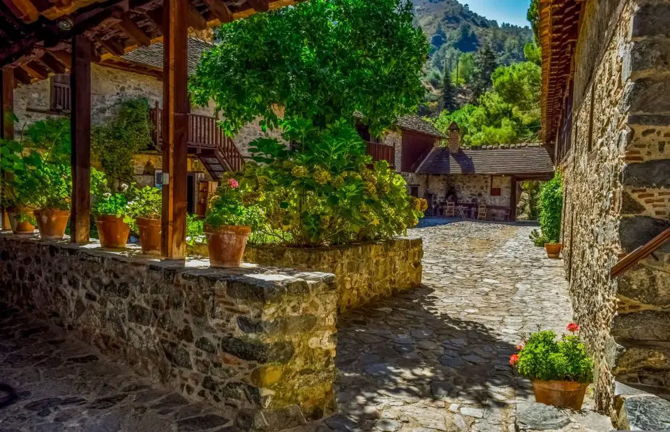 Rustic courtyard with stone walls and plants.
