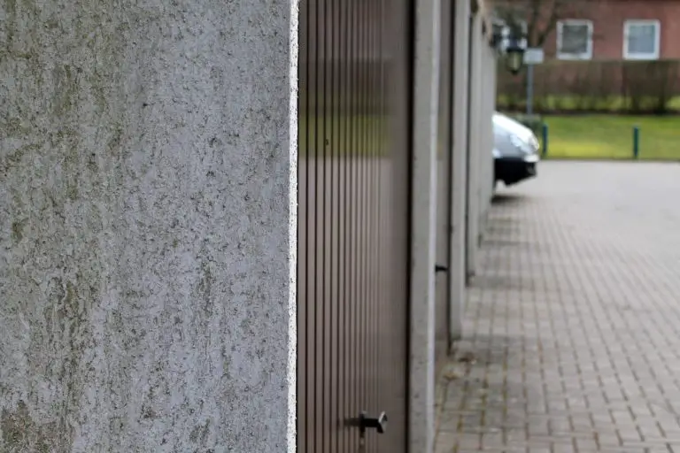 Row of garage doors along a concrete path.
