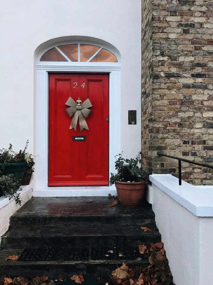 Red door with bow, brick house entrance
