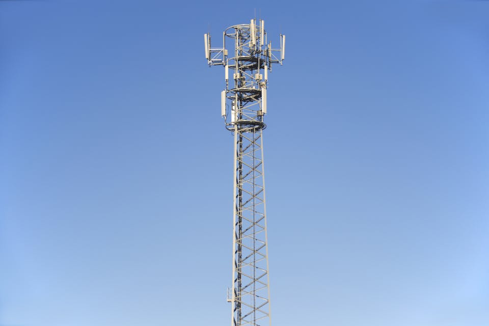 Tall communication tower under clear blue sky.