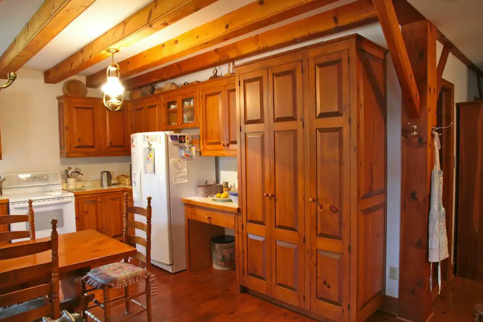 Rustic kitchen with wooden cabinets and dining table.