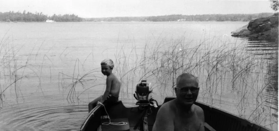 Grandpa Maxwell and Steve in the ancient 18′ cedar strip motor boat getting ready for a fishing trip, about 1970.