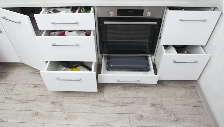 Modern kitchen cabinets with open drawers and oven.
