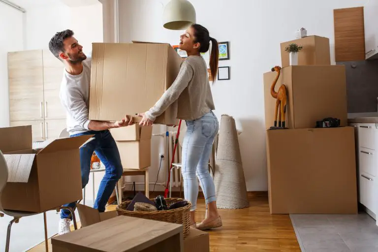 Couple moving boxes in their new home.