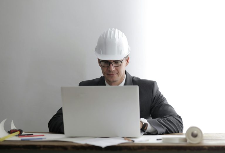 Engineer using laptop at desk.