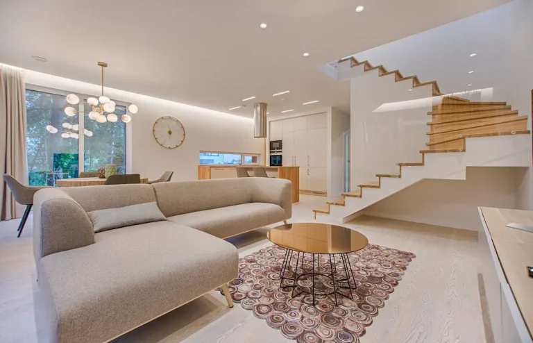 Modern living room with staircase and elegant furnishings.