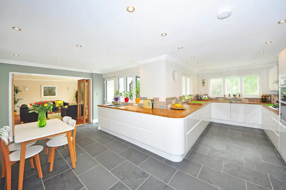 Modern kitchen with white cabinets and dining area.