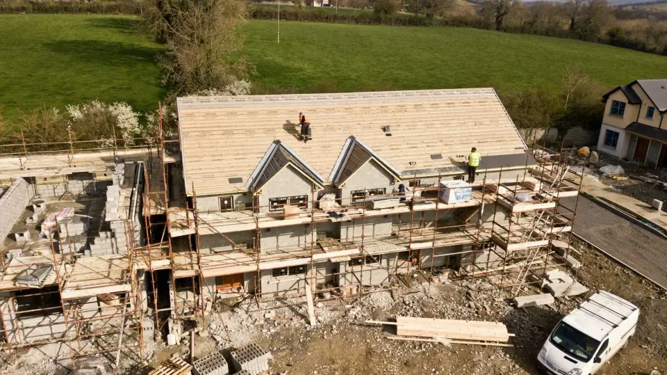 Construction workers building a house roof.