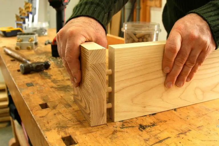 Woodworker assembling wooden joints on workbench.