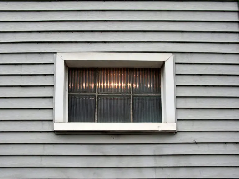 Small window on a grey wooden wall