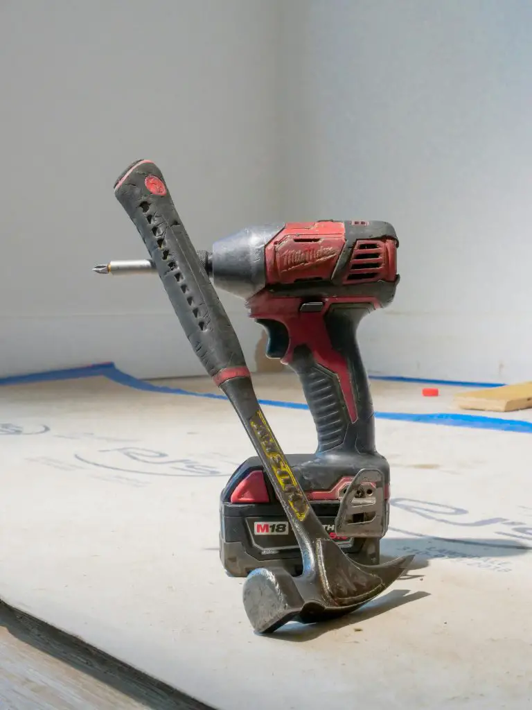 Hammer and drill on construction site floor.