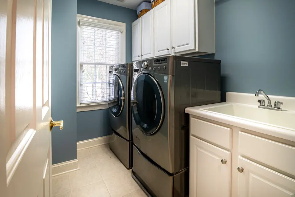 A clean, organized laundry room featuring modern appliances and ample storage.