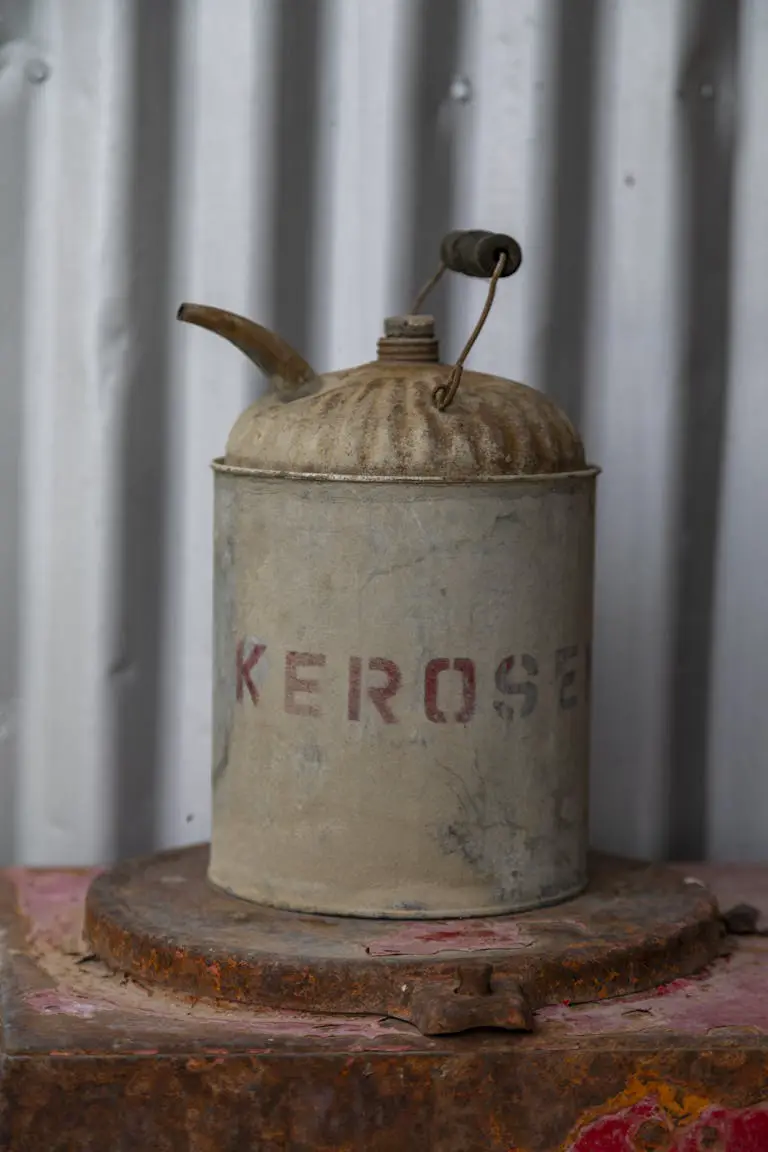 Close-up of an old, rusty kerosene can on a metal surface with corrugated backdrop.