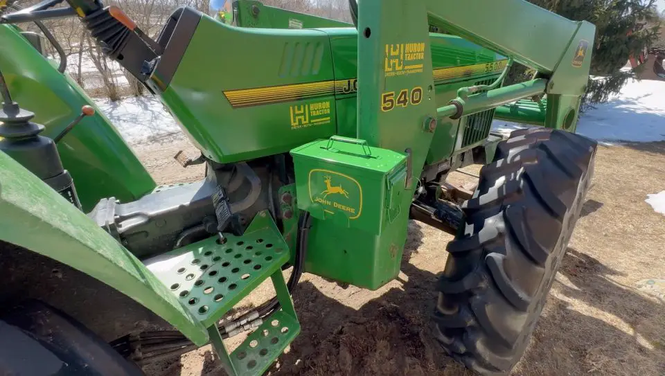 Green John Deere tractor with large rear tire.