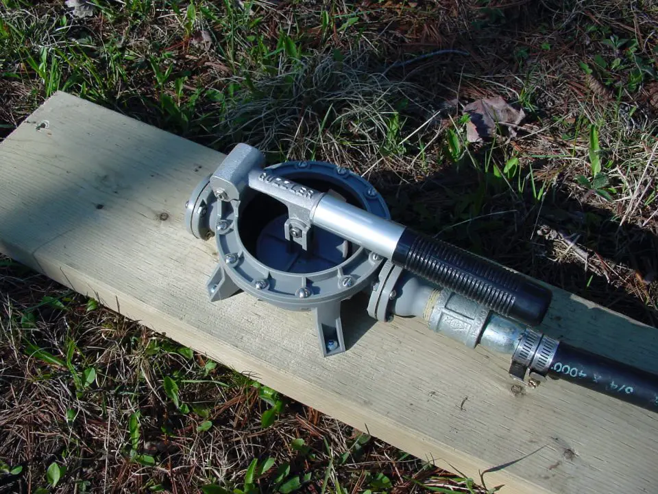Manual pump on wooden plank outdoors.