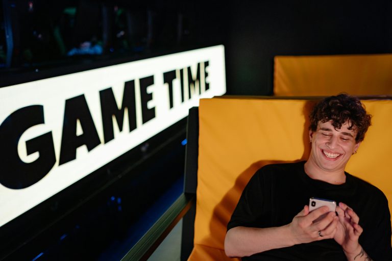 Smiling person on phone, game time sign