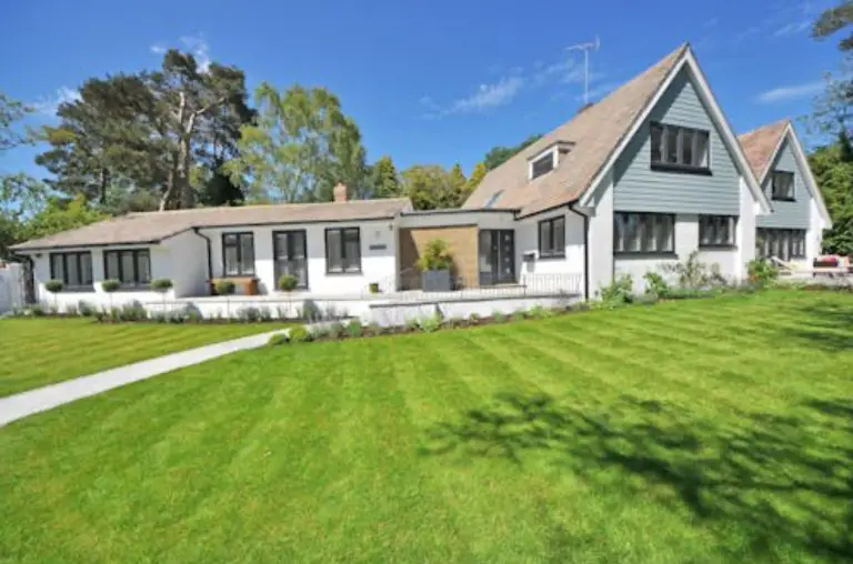 Spacious house with green lawn and trees.