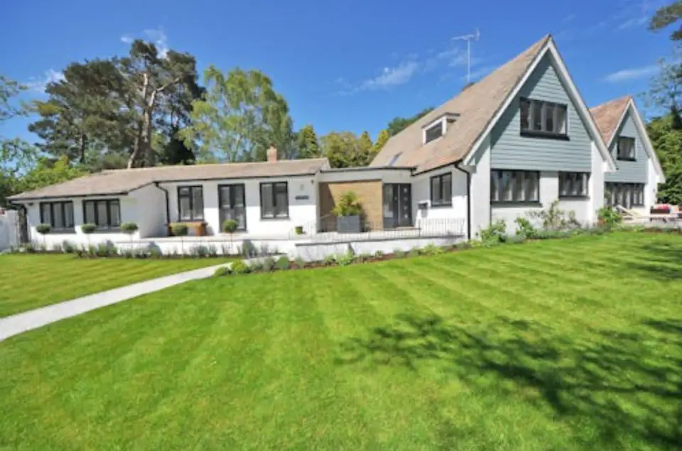 Spacious house with green lawn and trees.