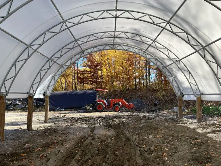 Red tractor under semi-circular canopy in autumn.