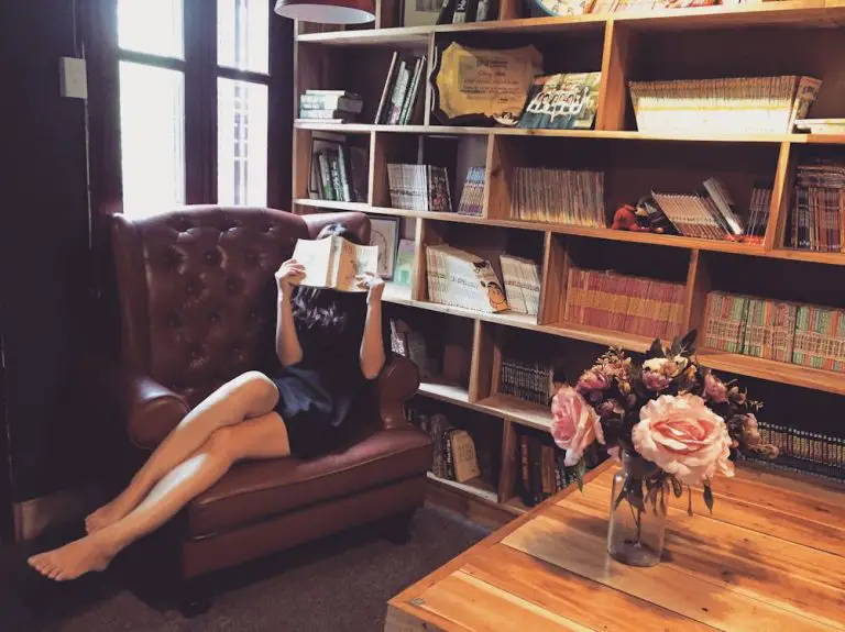 Person reading book in cozy library corner