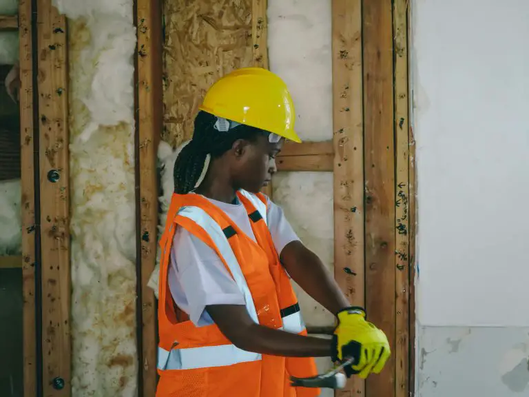 Construction worker in safety gear holding a tool
