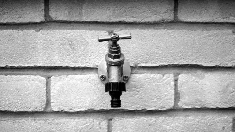 Outdoor water tap on brick wall