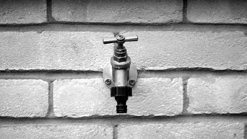 Outdoor water tap on brick wall