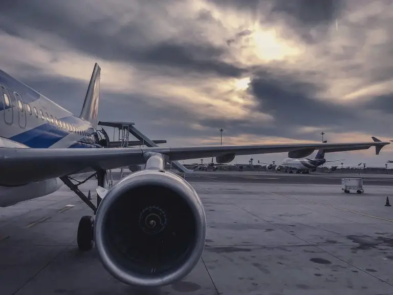 Airplane on runway during sunset with cloudy sky