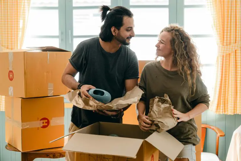 Couple unpacking boxes in new home.