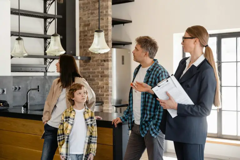Realtor showing family a modern kitchen space.