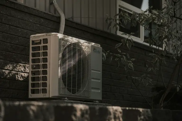 Outdoor air conditioner unit on brick wall.