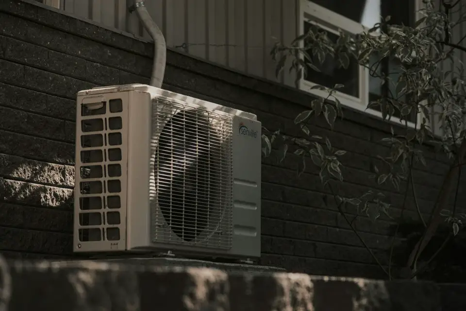 Outdoor air conditioner unit on brick wall.