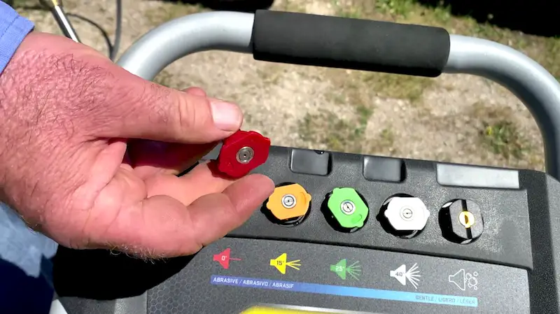 Person holding pressure washer spray nozzle