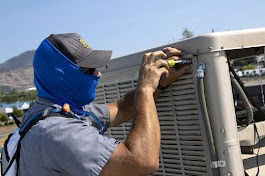 Worker fixing a vehicle under sunlight