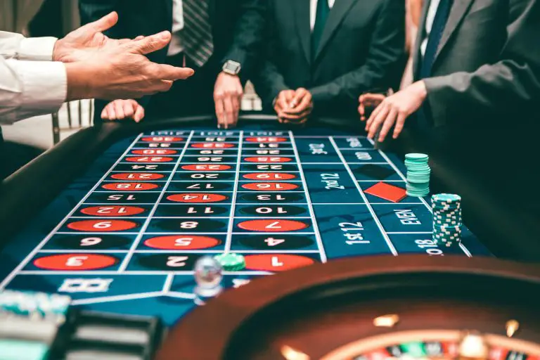 People playing roulette at casino table.