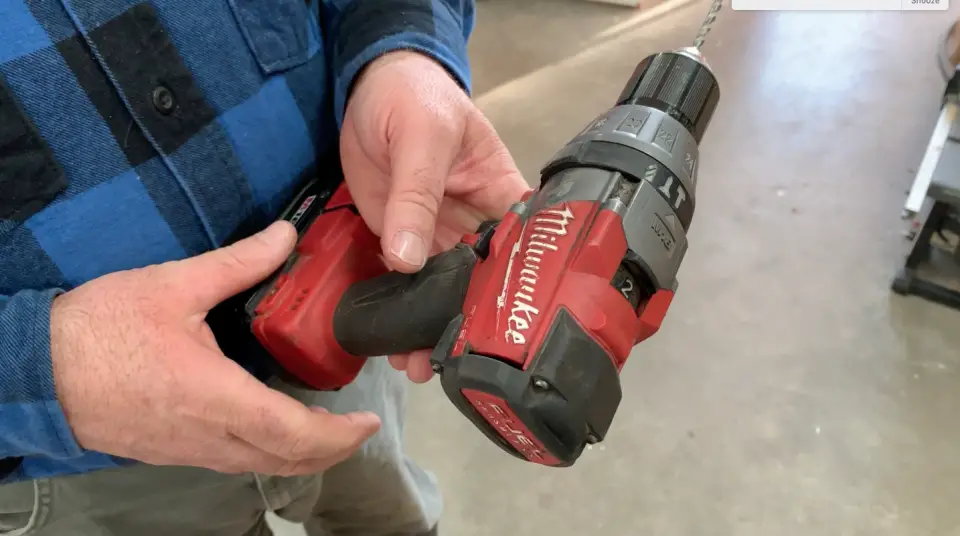 Person holding red cordless power drill