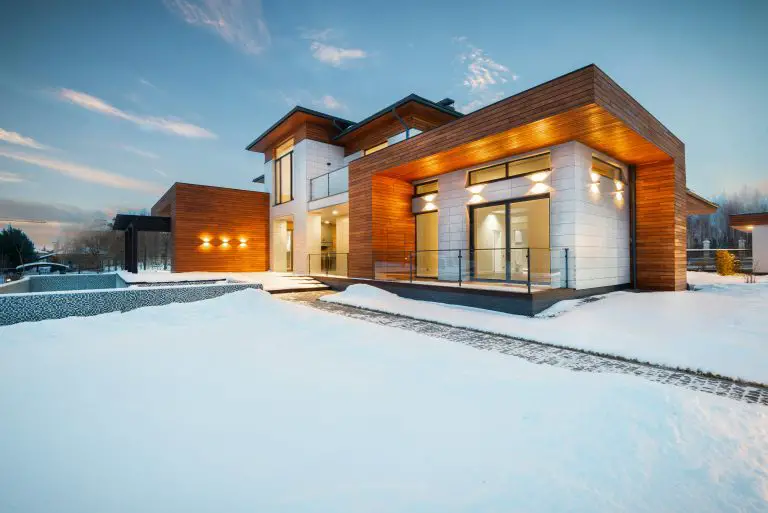 Modern house exterior with snow-covered landscape.