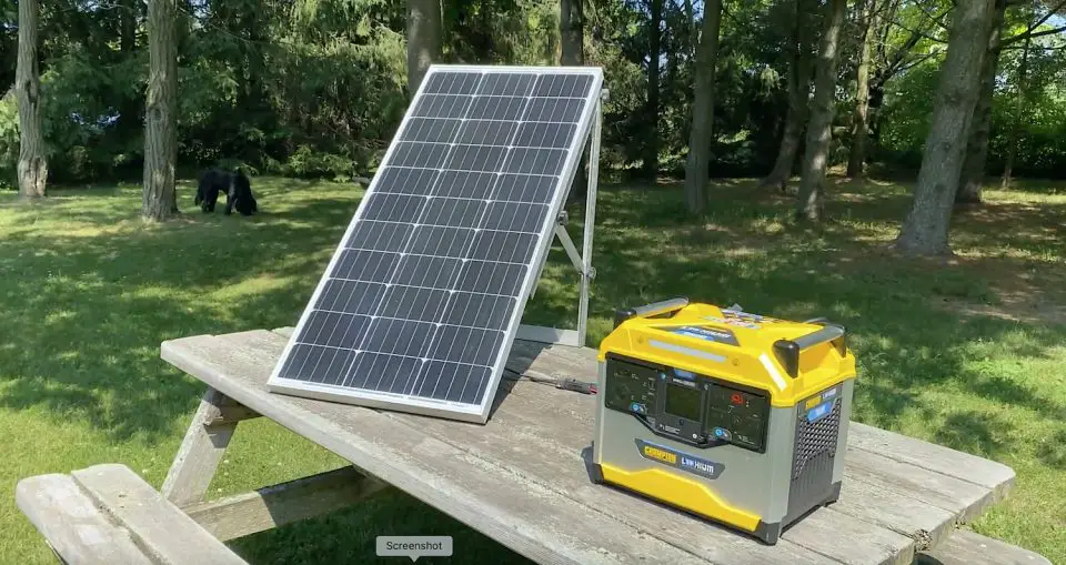 Portable solar panel and generator on picnic table.
