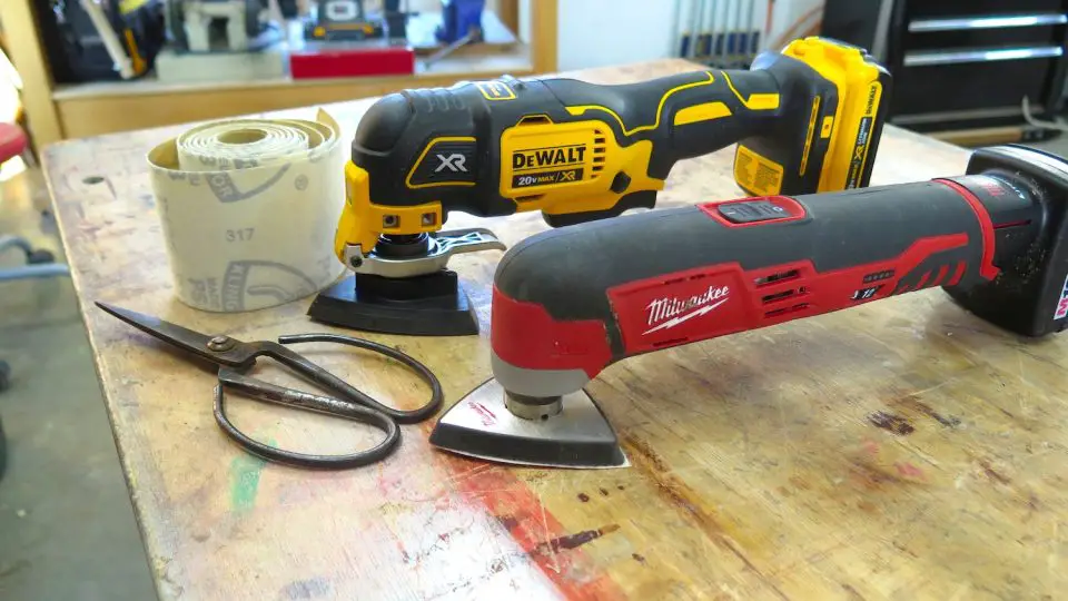 Power tools and sandpaper roll on workbench.