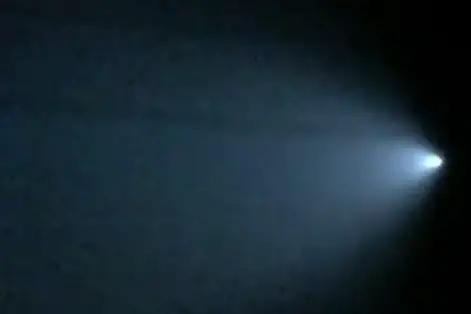 Bright comet with glowing tail in night sky.