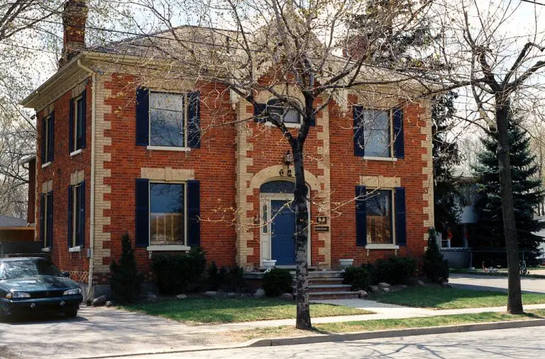 Historic brick house with blue shutters in neighbourhood.