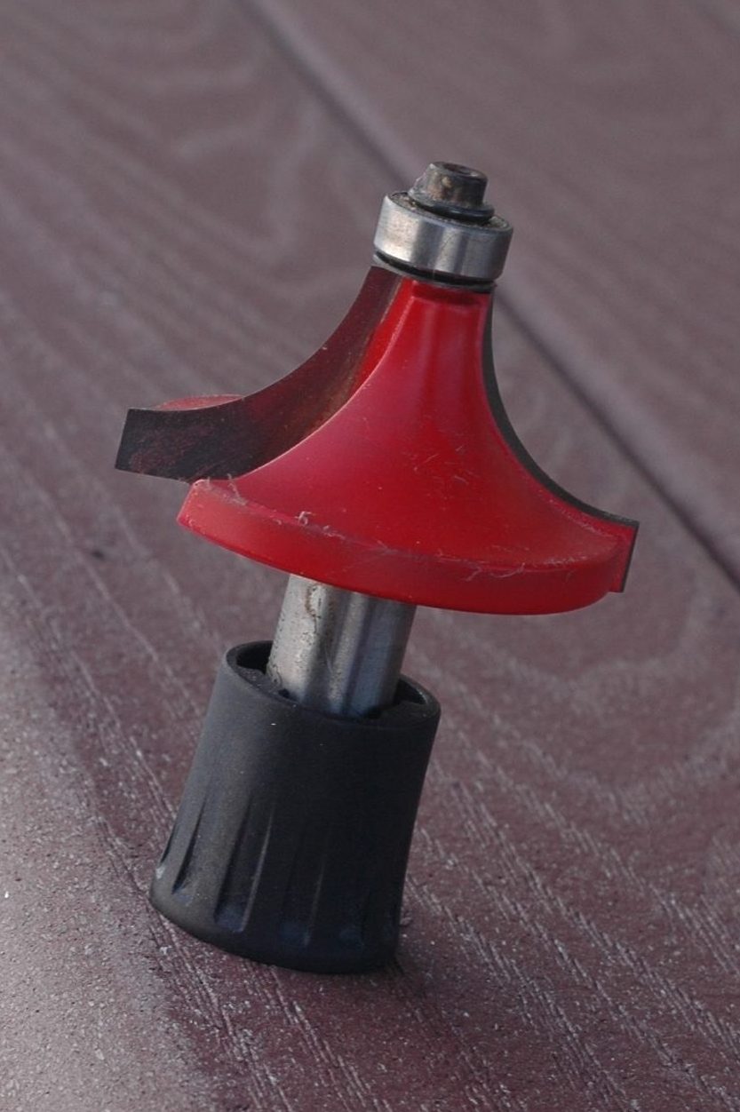 Red wood router bit on table edge.