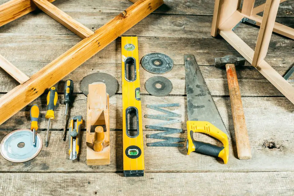 Assorted woodworking tools on wooden surface.