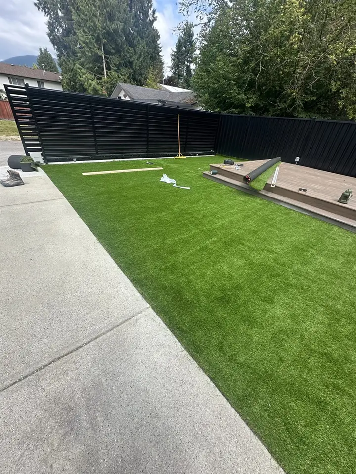 Backyard with artificial grass installation in progress.