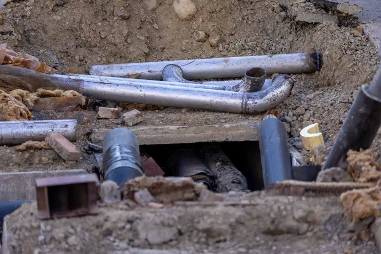 Exposed underground pipes during construction site excavation.