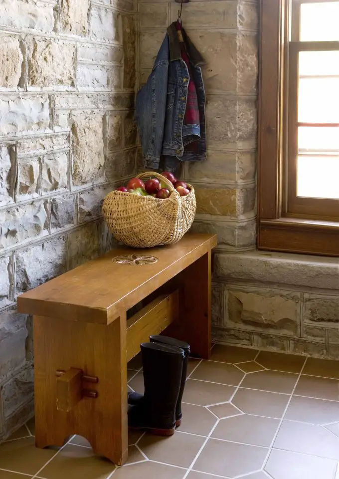 Rustic bench with basket of apples and boots.